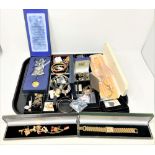 A tray of costume jewellery, gilt wristwatch with faux gold ingot dial, charm bracelet,