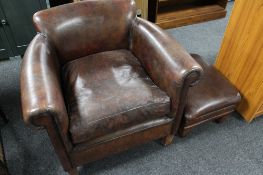 A brown leather armchair with matching footstool