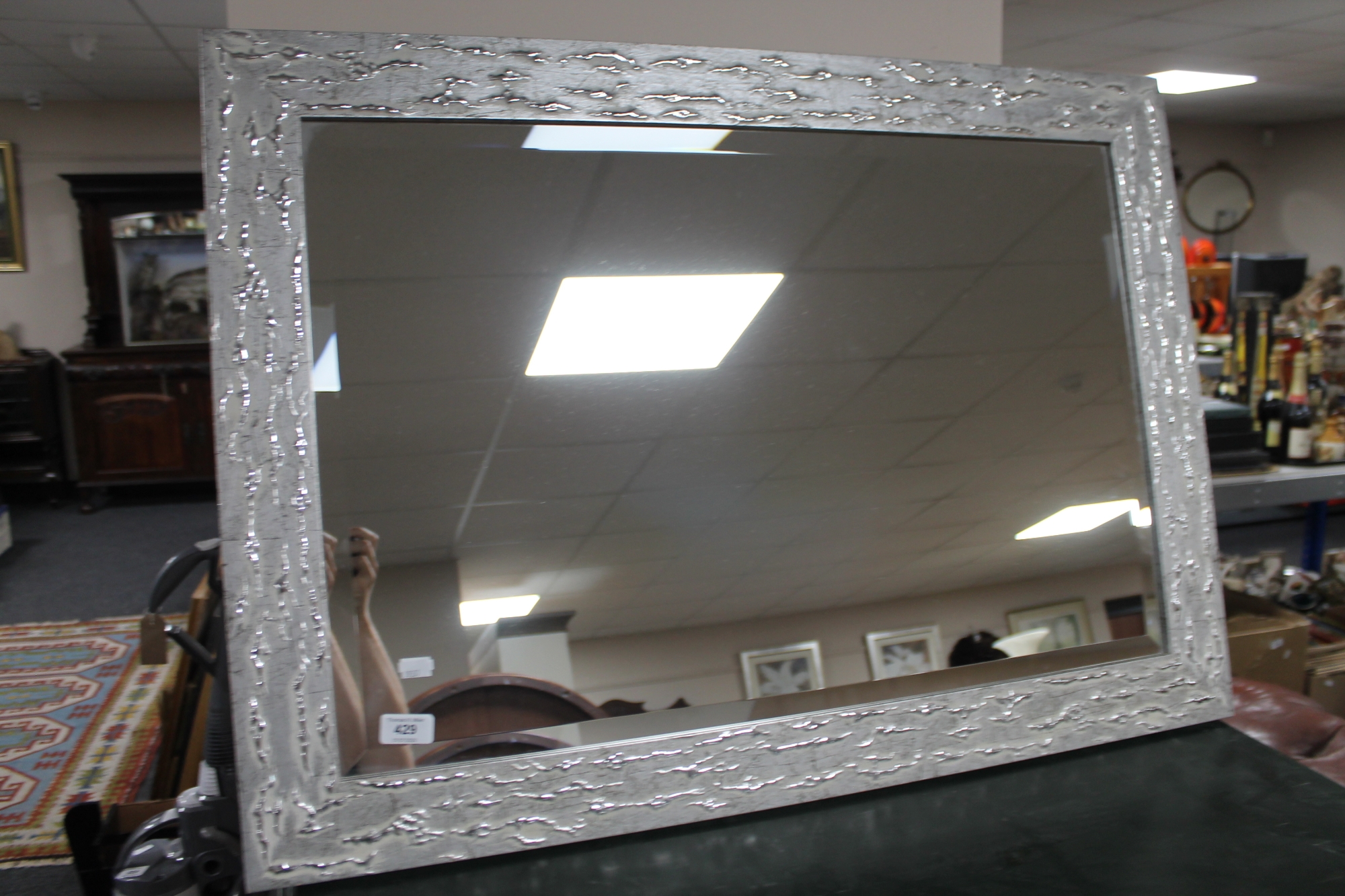 A contemporary silvered mirror CONDITION REPORT: 89cm by 64cm.