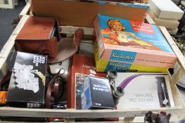 A crate of sundries, camera, child's sewing machine,