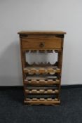 A pine bottle rack fitted with a drawer