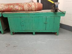 A large wooden work bench with metal vice,