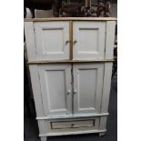 A cream double door cabinet fitted with a drawer.