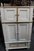 A cream double door cabinet fitted with a drawer.