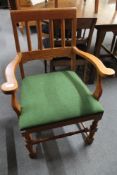 A light oak armchair in green upholstery.