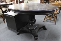 An antique pedestal occasional table on lion paw feet.