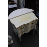 A white and gilt two drawer chest and a white d-shaped table.