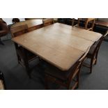 An oak gate leg table and five oak chairs.