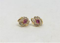 A pair of 18ct gold diamond and ruby earrings.