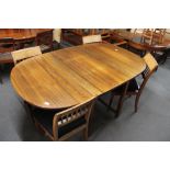 A mid century flap sided dining room table and four chairs.