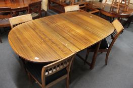 A mid century flap sided dining room table and four chairs.