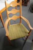 A light oak armchair with green striped fabric.