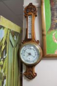 An early 20th century carved oak cased barometer with enamel dial