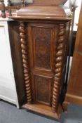 An carved oak cabinet with barley twist supports.