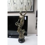 A patinated metal figure of a woman with hammer and anvil,