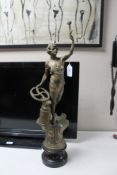 A patinated metal figure of a woman with hammer and anvil,