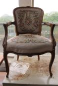A carved walnut armchair in tapestry fabric.