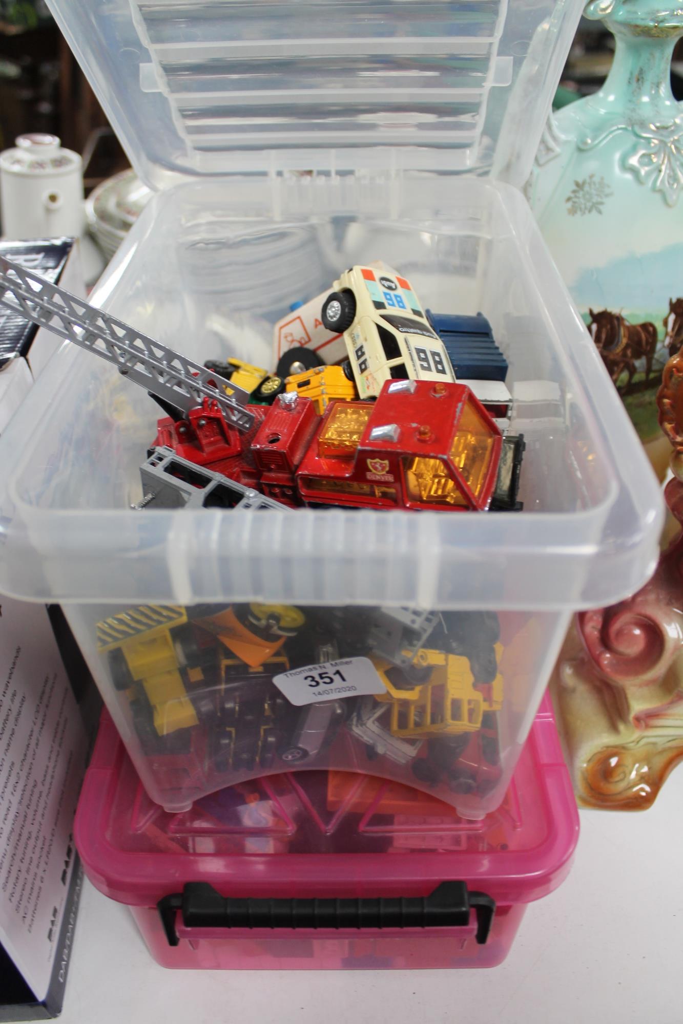 A crate of die cast vehicles and a box of lego