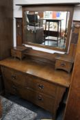 An Arts and Crafts Oak three piece bedroom suite - mirrored wardrobe,