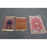 A small Persian prayer mat and two other similar rugs (3)