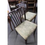 A pair of mahogany armchairs in green floral fabric.