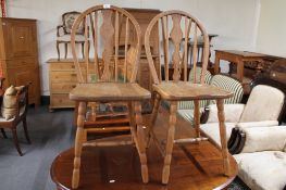A pair of light oak kitchen chairs.