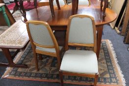 A mid century teak extending table and four Parker Knoll chairs