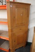 A mid century oak corner cabinet.