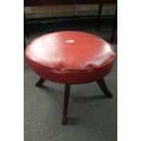 A red stitched leather footstool.