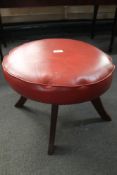 A red stitched leather footstool.