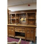 An Edwardian carved oak mirrored sideboard