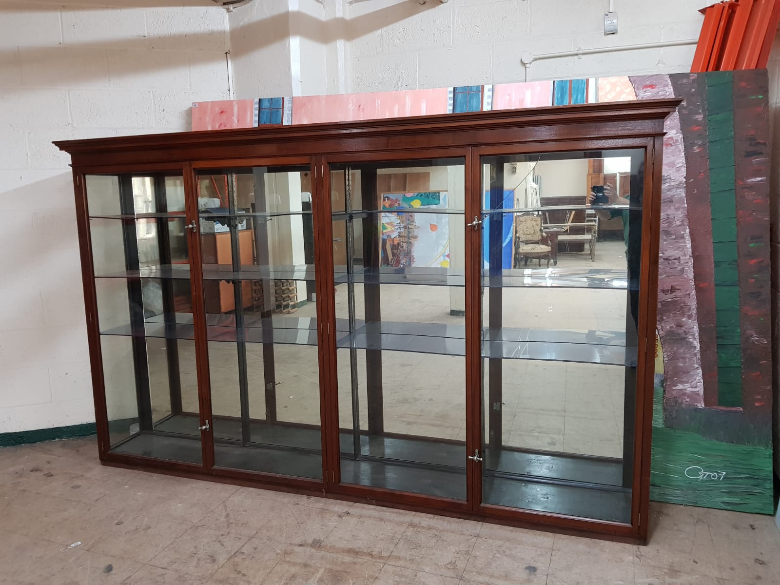 A Victorian mahogany four door shop display cabinet with mirrored panel back,