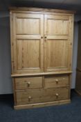 An antique style pine double door wardrobe with three drawer chest to base, height 222 cm,