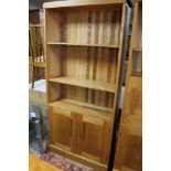 A pine bookcase with double cabinet below