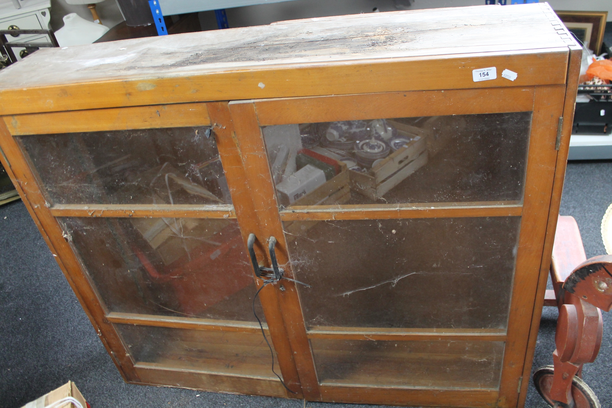 A glazed kitchen cabinet together with a further wooden bookcase