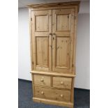 A pine double door wardrobe with three drawer chest in base, width 100 cm,