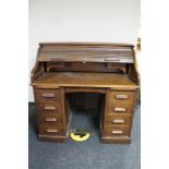 An Edwardian oak roll topped desk