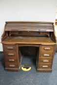 An Edwardian oak roll topped desk