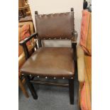 A brown studded leather armchair