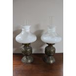 A pair of brass and glass oil lamps