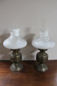 A pair of brass and glass oil lamps