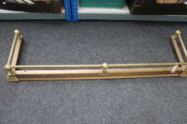 An Edwardian brass fire curb