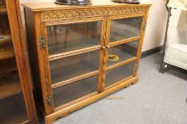 A carved oak double door glazed bookcase,