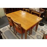 A mid century light oak dining table and four chairs