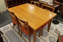 A mid century light oak dining table and four chairs