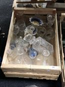 A crate of glass decanters,