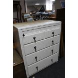 A painted white chest of five drawers