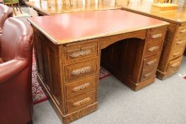 A Victorian carved oak pedestal desk with red leather top,