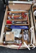 A crate of stainless steel cutlery