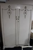 A three piece cream and gilt bedroom suite - double wardrobe, dressing table with stool,